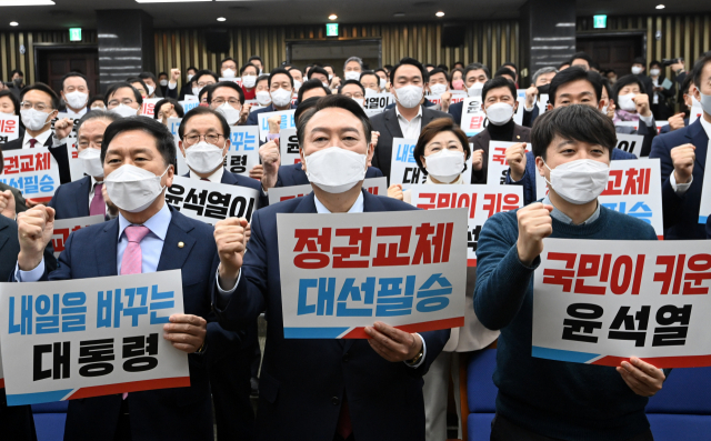 윤석열(가운데) 국민의힘 대선 후보와 이준석 대표, 김기현 원내대표가 공식 선거운동 하루 전날인 14일 국회에서 열린 의원총회에서 구호를 외치고 있다. /성형주 기자