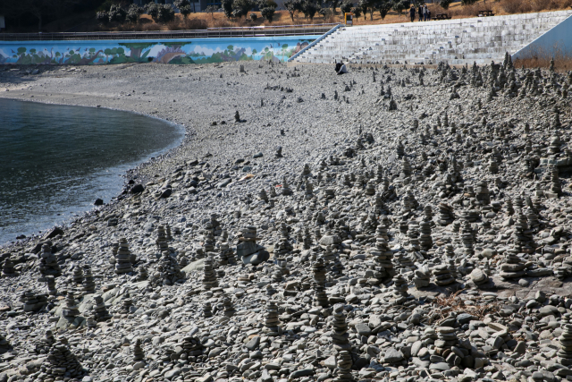 상족암 몽돌해변에 방문객들이 쌓은 돌탑이 셀 수 없을 만큼 많이 세워져 있다.