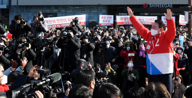 윤석열 국민의힘 대선 후보가 15일 대구 동구 동대구역 광장에서 유세 차량으로 이동하며 인사하고 있다. /연합뉴스