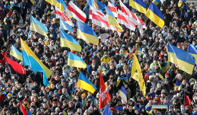 우크라이나 시민 수천명이 지난 12일(현지시간) 수도 키예프 거리로 나와 러시아의 위협에 맞서 단결하겠다는 의지를 내보이며 국기를 든 채 행진에 참여하고 있다./키예프=로이터연합뉴스