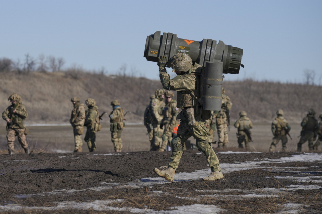 우크라이나 군인이 15일(현지 시간) 동부 돈바스 지역에서 진행된 훈련에서 대전차미사일(NLAW)을 운반하고 있다. AP연합뉴스