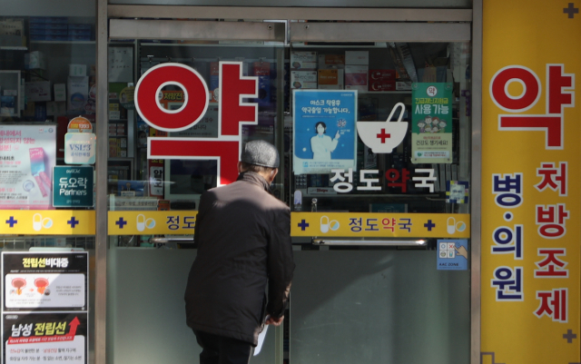 한 시민이 16일 서울 시내 약국 문을 열고 들어가고 있다. 연합뉴스