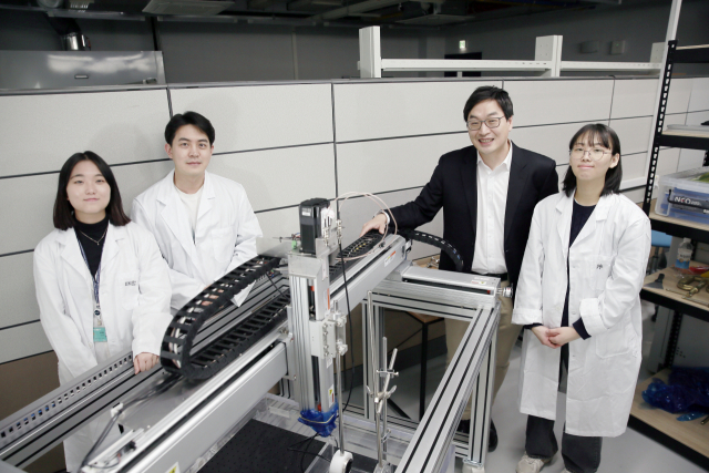 김건 교수 연구팀( 오른쪽 두번째 김건 교수). 가운데 장비가 메카노포어분자를 자극하는 초음파 장비다. /사진제공=UNIST