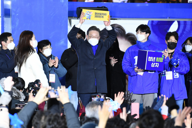 이재명 더불어민주당 대선 후보가 17일 홍대 상상마당에서 연설을 마친 뒤 ‘청년 희망 상자’에서 꺼낸 공약 카드를 치켜들고 공약 이행을 다짐하고 있다. / 연합뉴스