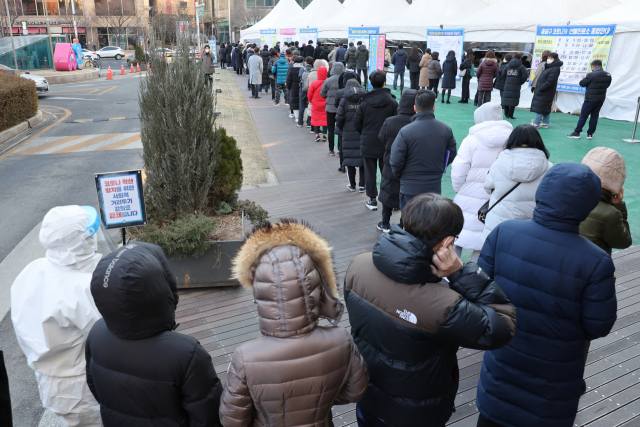 코로나19 사태 후 처음으로 하루 11만명에 육박하는 신규 확진자가 발생한 18일 서울 송파구 보건소에 마련된 선별검사소에서 시민들이 검사를 받기 위해 줄을 서 있다./연합뉴스