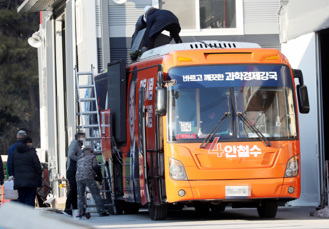 경찰이 국민의당 안철수 후보 유세버스에서 선거운동원과 운전기사가 사망한 사고를 수사 중인 가운데 지난 17일 안 후보 유세버스를 개조한 경기도 김포시 모 업체에서 관계자들이 안 후보 유세버스에 설치된 발광다이오드(LED) 전광판을 제거하는 작업을 하고 있다./연합뉴스