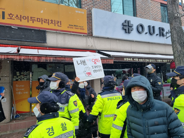 16일 광주 송정매일시장 건너편 도로에서 윤석열 국민의힘 대선 후보에 반대하는 사람이 ‘나쁜 열정 열차 王 무당정치 신천지유착 멈춰’ 손팻말을 들고 소리 지르고 있다./광주=조권형기자