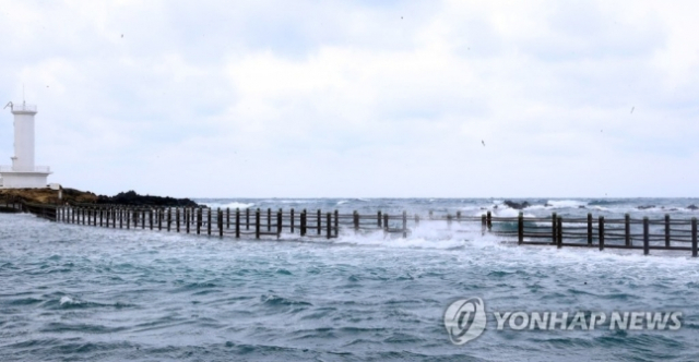 지난 19일 제주시 한경면 신창풍차해안도로 인근 싱계물공원 내 풍력발전기와 등대를 이어주는 다리가 만조때가 되자 물에 잠기고 있다./연합뉴스