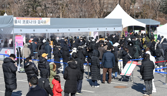 20일 서울 송파구 잠실종합운동장 제2주차장에 마련된 임시 선별진료소에서 시민들이 검사를 위해 줄을 서있다. 중앙방역대책본부는 이날 0시 기준으로 신규 확진자가 10만4천829명 늘어 누적 196만2천837명으로 집계됐다고 밝혔다./권욱 기자 2022.02.20