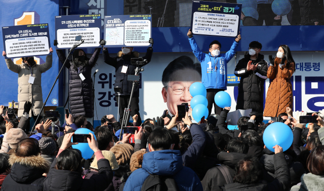 이재명 더불어민주당 대선 후보가 20일 경기도 안양시 안양중앙공원에서 열린 현장 유세에서 안양시 공약을 들어보이고 있다. /연합뉴스