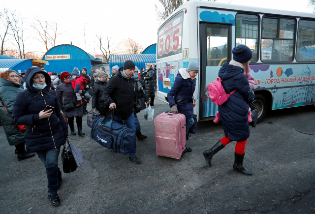 친 러시아 반군이 통제하는 우크라이나 동부 도네츠크에서 지난 19일(현지시간) 피란길에 나선 주민들이 짐을 싸 들고 버스에 오르고 있다./연합뉴스
