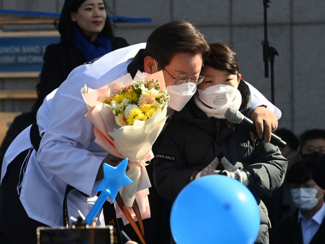 이재명 더불어민주당 대선후보가 20일 경기도 수원시 만석공원에서 열린 '검증된 실력과 성과, 대한민국을 위해 일하겠습니다!' 수원 유세에서 한 어린이 지지자에게 꽃다발을 받고 있다./수원=권욱 기자 2022.02.20