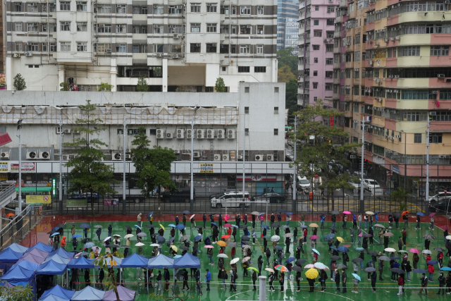 지난 17일 홍콩의 한 학교 운동장에 코로나19 검사를 받으려는 시민들이 길게 줄을 서 있다. 로이터연합뉴스