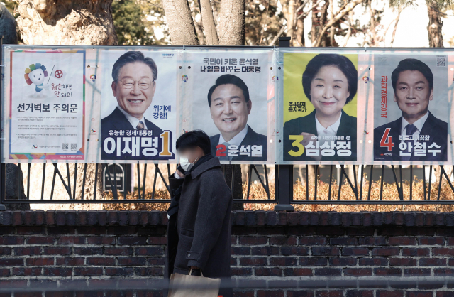 20일 서울 대학로에 부착된 제20대 대통령 선거 벽보 앞을 시민이 지나가고 있다. 연합뉴스