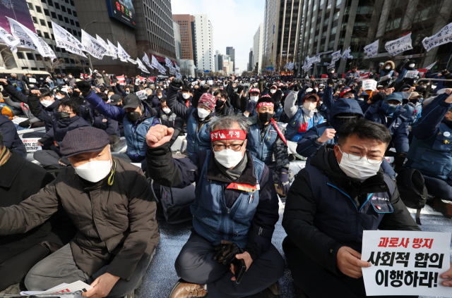 진경호 택배노조 위원장(가운데)이 21일 청계광장에서 민주노총 전국택배노조 주최로 열린 2022 전국 택배 노동자대회에서 구호를 외치고 있다. 연합뉴스