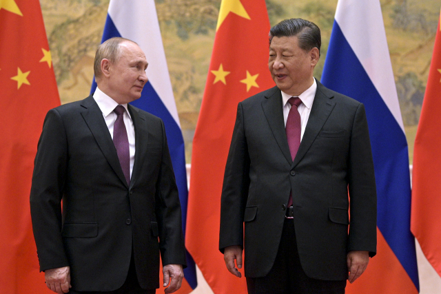 시진핑(오른쪽) 중국 국가주석과 블라디미르 푸틴 러시아 대통령이 동계 올림픽 개막식이 열린 4일 중국 베이징에서 정상회담을 열기 전 양국 국기 앞에서 환담하며 사진 촬영을 하고 있다. AP연합뉴스