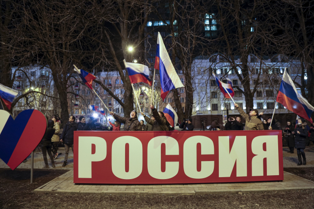 지난 21일 우크라이나 동부의 친러세력이 장악한 도네츠크에서 주민들이 러시아 국기를 흔들며 환호하고 있다./연합뉴스
