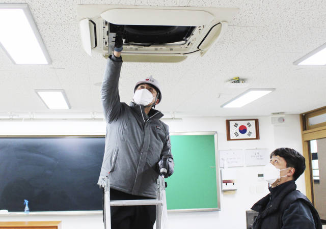 LG전자 하이엠솔루텍 직원이 개학을 앞둔 학교를 방문해 시스템 에어컨을 점검하고 있다./사진제공=LG전자 하이엠솔루텍