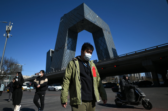 22일 중국 베이징의 중국중앙(CC)TV 건물 근처를 걷고 있는 사람들. AFP연합뉴스