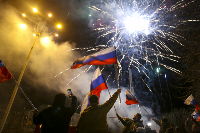 블라디미르 푸틴 러시아 대통령이 도네츠크인민공화국(DPR)과 루간스크인민공화국(LPR)의 독립을 승인한 21일(현지 시간) 도네츠크 중심부에서 주민들이 러시아 국기를 흔들며 독립을 축하하고 있다. AP연합뉴스