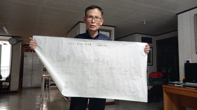 송정근 씨가 충남 천안 자택에서 자신이 직접 그린 우리 구축함 ‘충무공 이순신호’의 도면을 펼쳐 보이고 있다.