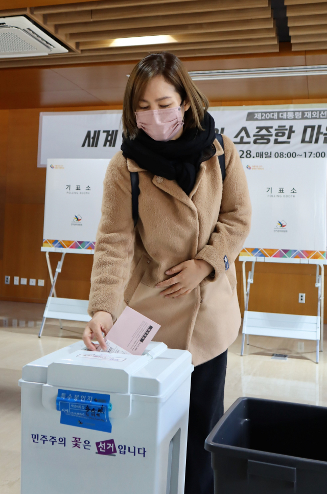 제20대 대통령 재외선거가 시작된 23일 베이징 주중한국대사관에서 한 교민이 투표지를 투표함에 넣고 있다. 김광수특파원