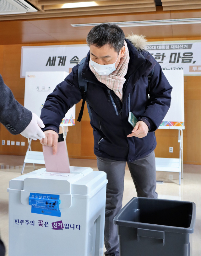 제20대 대통령 재외선거가 시작된 23일 베이징 주중한국대사관에서 한 교민이 투표지를 투표함에 넣고 있다. 김광수특파원