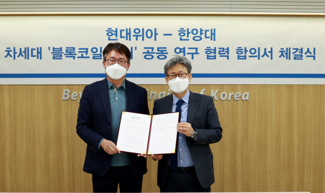 원광민(왼쪽) 현대위아 차량부품연구센터장 상무와 이주 한양대 교수가 지난 22일 서울 한양대학교에서 ‘블록코일을 적용한 모터 사업 협력을 위한 합의서(MOA)’를 체결하고 있다. 사진 제공=현대위아