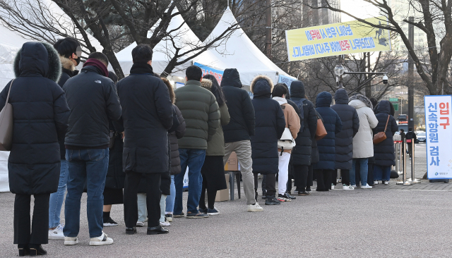 코로나19 신규 확진 환자가 하루새 7만여명이 폭증, 17만명대로 치솟아 최다 기록이 경신된 23일 서울 영등포구 여의도공원 선별검사소에서 시민들이 줄지어 PCR과 신속항원검사를 기다리고 있다. /오승현 기자