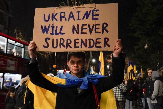 지난 23일(현지시간) 영국 런던의 러시아 대사관 앞에서 한 남성이 우크라이나 국기를 두르고 러시아 규탄 시위를 벌이고 있다./런던=연합뉴스