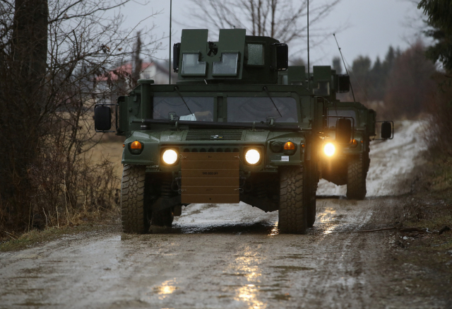 미 육군 제82공수사단 소속 군용 차량(험비)이 23일(현지시간) 우크라이나 접경 지역인 폴란드 동부 아르와모프 인근의 공군기지로 이동하고 있다./연합뉴스