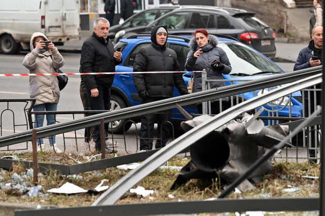 24일(이하 현지시간) 우크라이나 수도 키예프에 떨어진 미사일 잔해를 키예프 시민들이 바라보고 있다. /연합뉴스