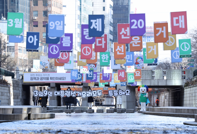 중앙선거관리위원회 직원들이 지난 21일 오후 서울 청계천에서 제20대 대통령선거 투표를 독려하고 있다. 연합뉴스