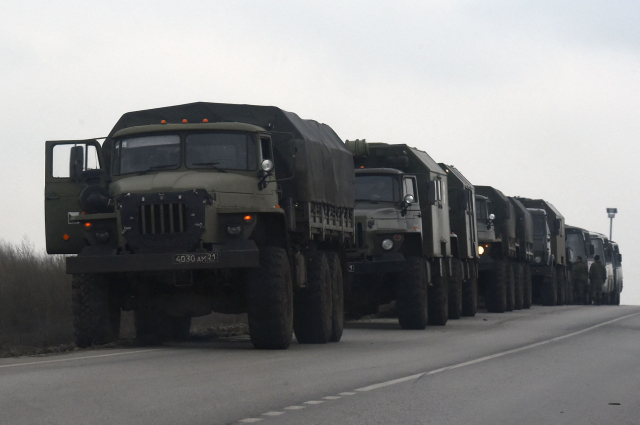 23일(현지시간) 친(親)러시아 반군이 통제하는 우크라이나 동부 도네츠크와 국경을 접한 러시아 남부 로스토프 지역 길가에 러시아 군용 트럭과 버스들이 줄지어 서 있다. /연합뉴스