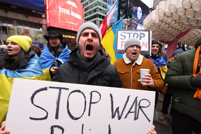 미국 뉴욕 타임스퀘어에서 시위대가 우크라이나에 대한 지를 담은 푯말을 들고 있다./연합뉴스