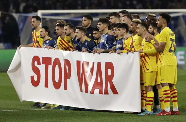 24일(현지 시간) FC바르셀로나와 나폴리의 UEFA 유로파리그 플레이오프 2차전에 앞서 양 팀 선수들이 전쟁 중단을 촉구하는 플래카드를 들고 기념 촬영을 하고 있다. 로이터연합뉴스