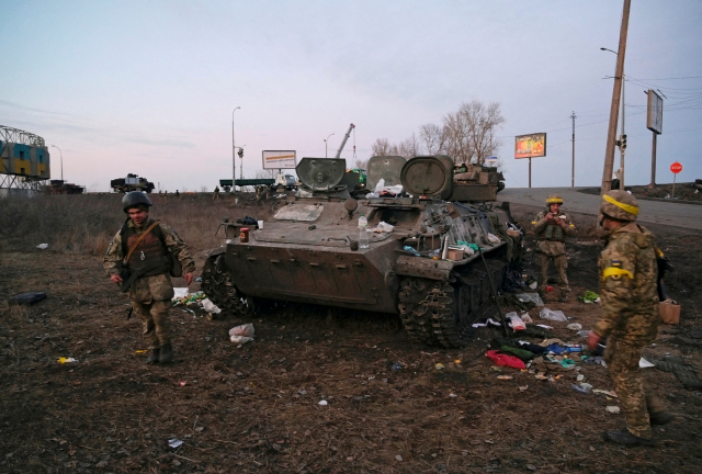 러시아가 우크라이나를 전면 침공한 24일(현지시간) 우크라이나 북동부 하리코프에서 군인들이 부서진 장갑차를 살펴보고 있다. 우크라이나군은 이 장갑차가 교전 중 파괴된 러시아군 소속이라고 주장했다. 로이터연합뉴스