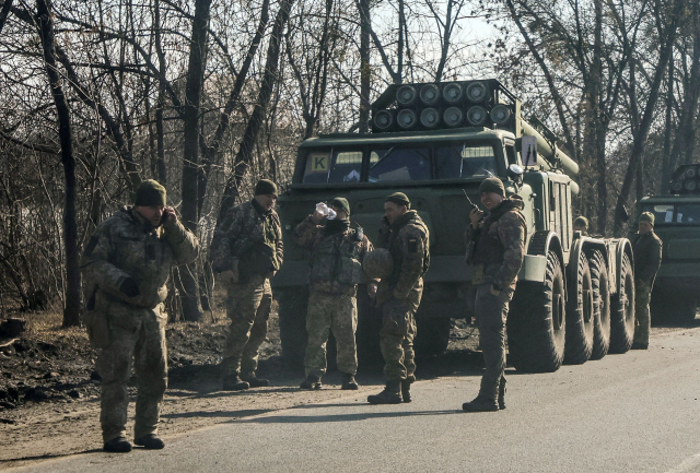 24일(현지 시간) 블라디미르 푸틴 러시아 대통령이 군사공격을 지시한 뒤 우크라이나 군인이 미사일시스템 옆에 서 있다. 로이터연합뉴스