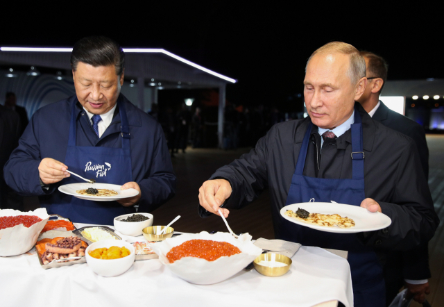 지난 2018년 러시아 블라디보스토크에서 블라디미르 푸틴 러시아 대통령과 시진핑 중국 국가주석이 한 행사에 참석해 함께 팬케이크를 요리하고 있다. EPA연합뉴스