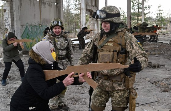 우크라이나 키예프 외곽에서 모형총으로 군사훈련을 받는 여성의 모습./연합뉴스