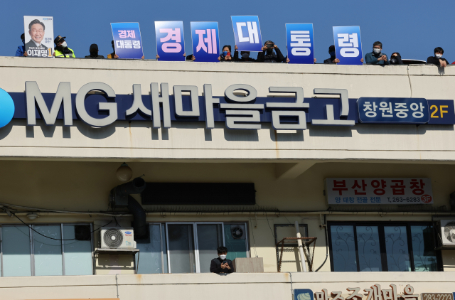 27일 이재명 더불어민주당 대선 후보의 유세가 열린 경남 창원시 상남분수광장 인근 건물 옥상에 지지자들이 피켓을 들고 이 후보를 응원하고 있다. / 연합뉴스