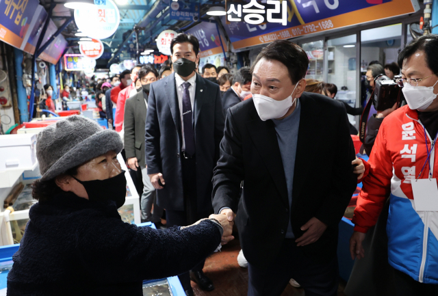 윤석열 국민의힘 대선 후보가 27일 오후 경북 포항시 죽도시장을 찾아 상인들과 인사를 나누고 있다./연합뉴스