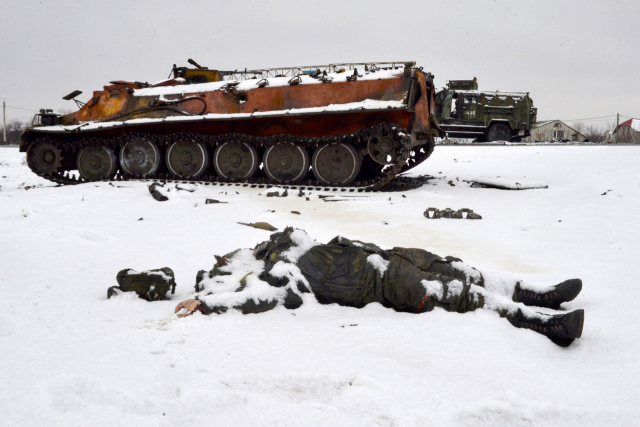 우크라이나 동북부 하리코프 외곽 도로에 26일(현지시간) 파괴된 러시아군 차량들이 멈춰서 있는 가운데 한 러시아 병사의 시신이 널부러져 있다. /연합뉴스