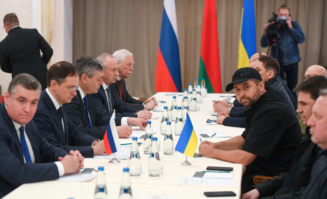 블라디미르 푸틴 대통령의 보좌관인 블라디미르 메딘스키(왼쪽 두 번째)가 이끄는 러시아 협상단이 28일 벨라루스 고멜의 한 장소에서 우크라이나 집권당 ‘국민의 종’ 대표인 다비트 아라하먀(오른쪽 세 번째) 등 우크라이나 대표단과 테이블에 마주 앉아 무거운 얼굴로 대화하고 있다. 타스연합뉴스