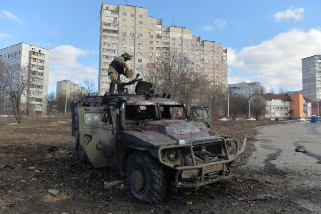 우크라니아 제2 도시 하리코프에서 27일(현지 시간) 한 방위군 대원이 파괴된 러시아 보병 기동차량 GAZ 티그르를 살펴보고 있다. AFP연합뉴스