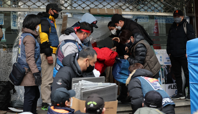 택배노조 조합원들이 28일 서울 CJ대한통운 본사 1층을 점거하면서 사용했던 물품들을 건물 밖으로 옮기고 있다. 연합뉴스