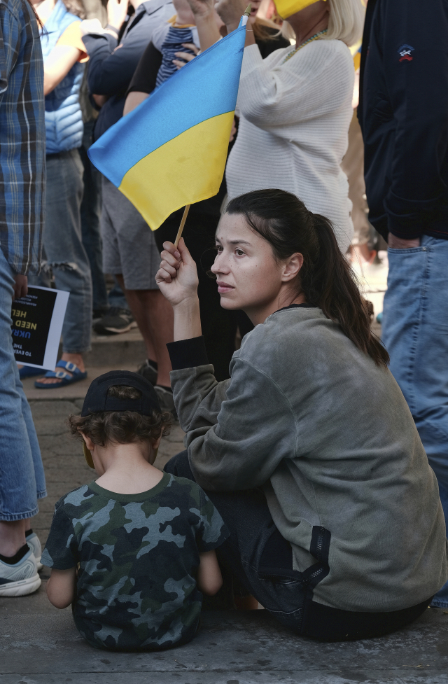 캘리포니아 산타모니카에서 러시아의 우크라이나 침공에 반대하는 시위가 진행되는 동안 한 젊은 여성이 앉아서 우크라이나 국기를 흔들고 있다. /AP연합뉴스