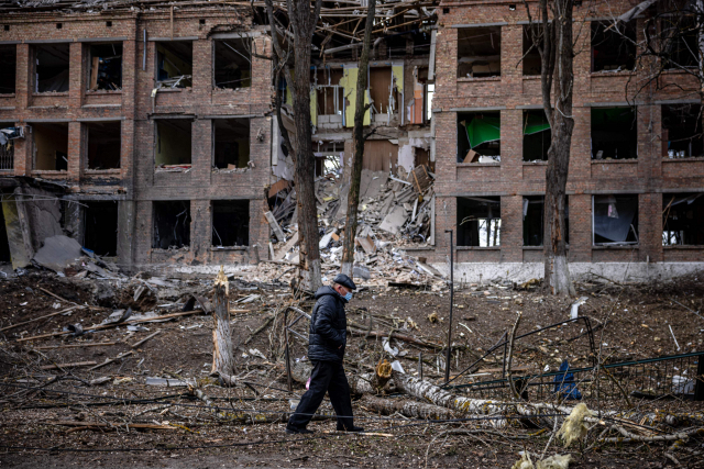 지난달 27일(현지 시간) 우크라이나 수도 키예프 인근 바실키프에서 한 남성이 러시아의 미사일 공격으로 파괴된 한 건물 앞을 지나고 있다. 연합뉴스