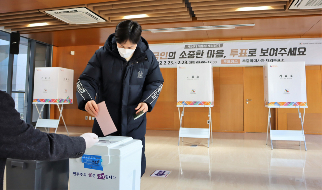 제20대 대통령 재외선거가 시작된 23일 베이징 주중한국대사관에서 한 교민이 투표지를 투표함에 넣고 있다. 김광수특파원