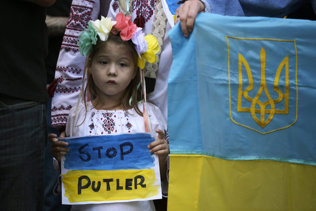 1일(현지 시간) 아르헨티나 부에노스아이레스에 있는 러시아 대사관 앞에서 한 아이가 ‘푸틀러(푸틴과 히틀러의 합성어) 멈춰’라고 적힌 종이를 들고 러시아의 우크라이나 침공을 규탄하는 시위를 벌이고 있다. AFP연합뉴스